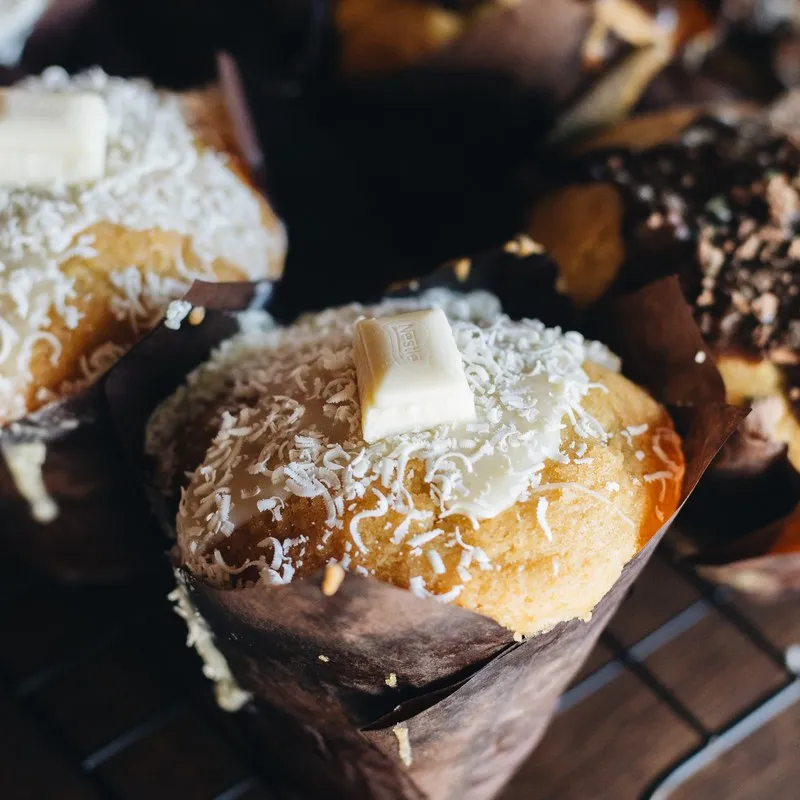 Coconut and white chocolate muffin on a cooling rack
