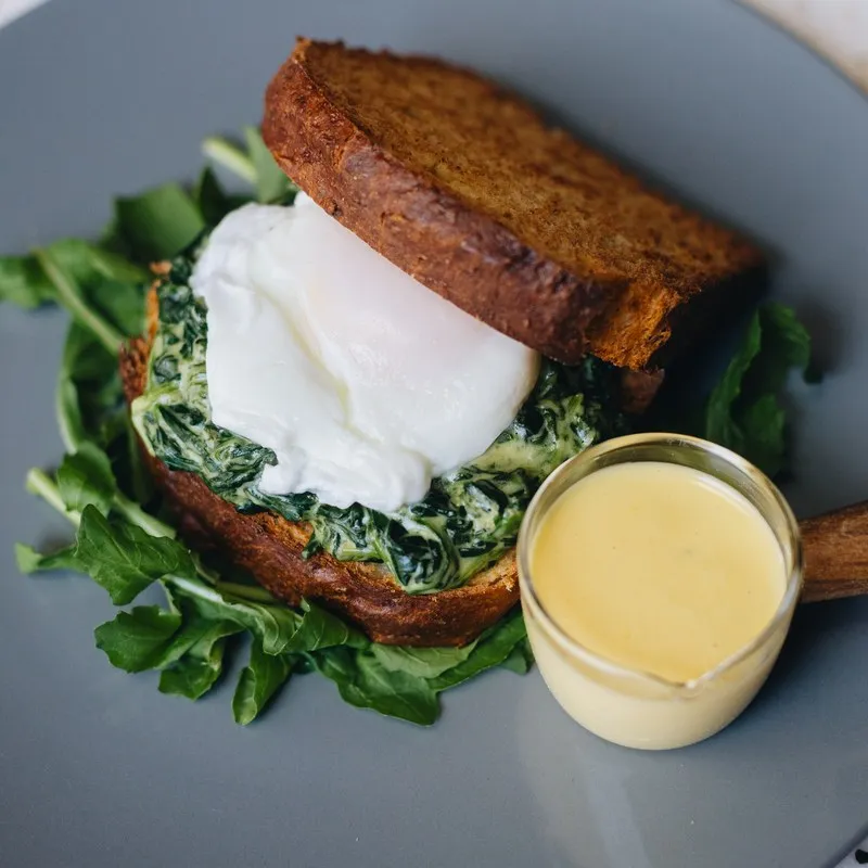 Eggs benedict with hollandaise on a bed of rocket