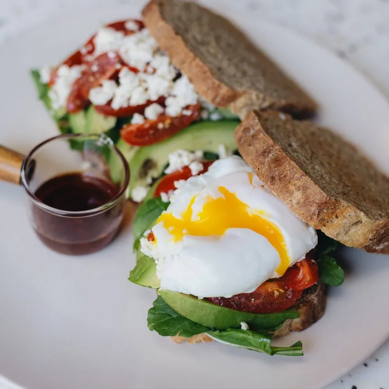 Open sandwich topped with feta and poached egg